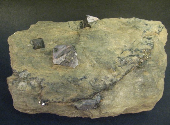 Dipyramidální krystaly ocelově šedého arsenopyritu v hornině